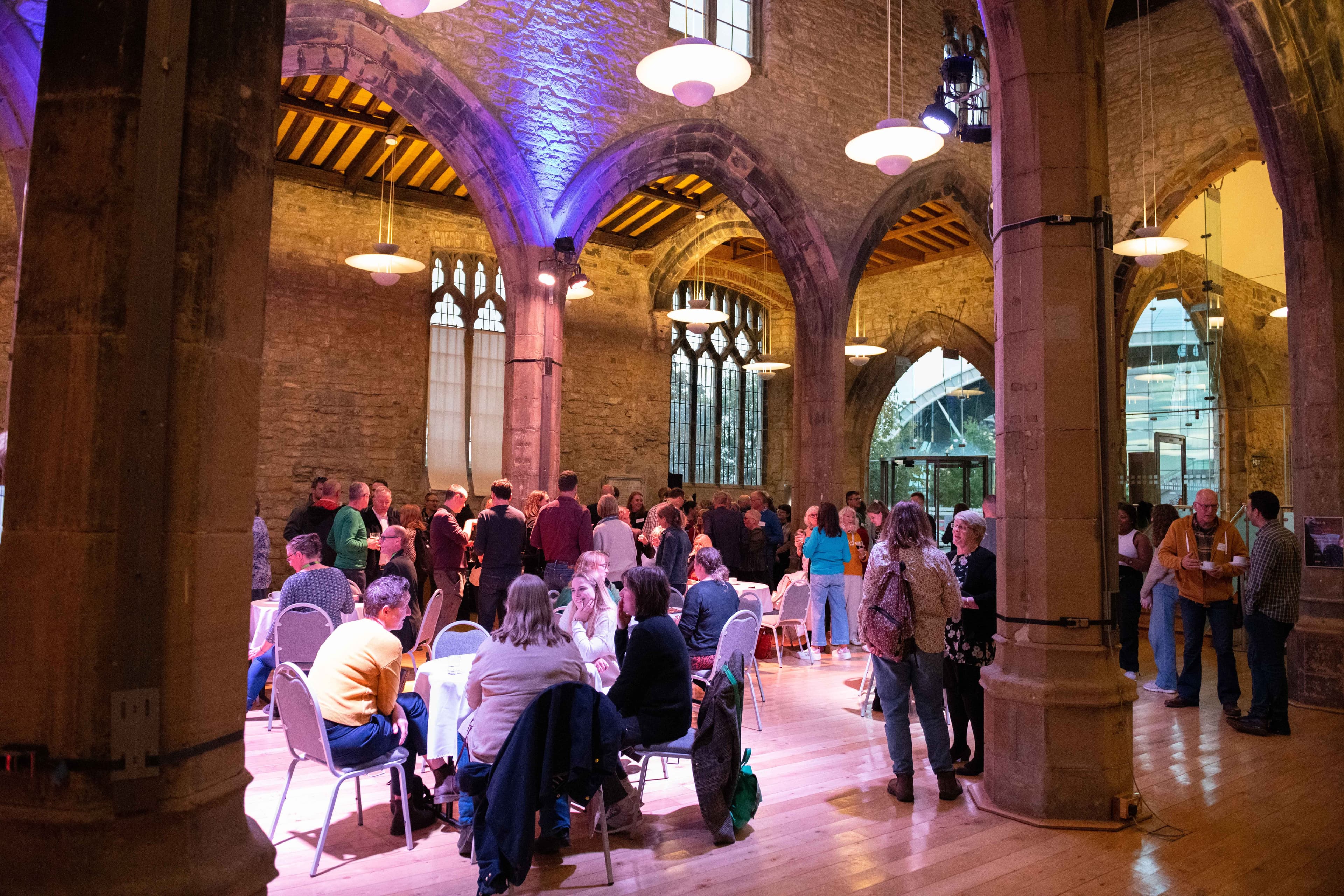 Delegates socialising in a historic church at our 2023 conference.